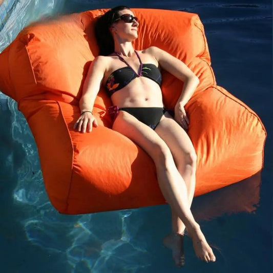 Bondi Premium Pool floating pool beanbag cover โ Orange, lifestyle image of a woman enjoying buoyant support in the water