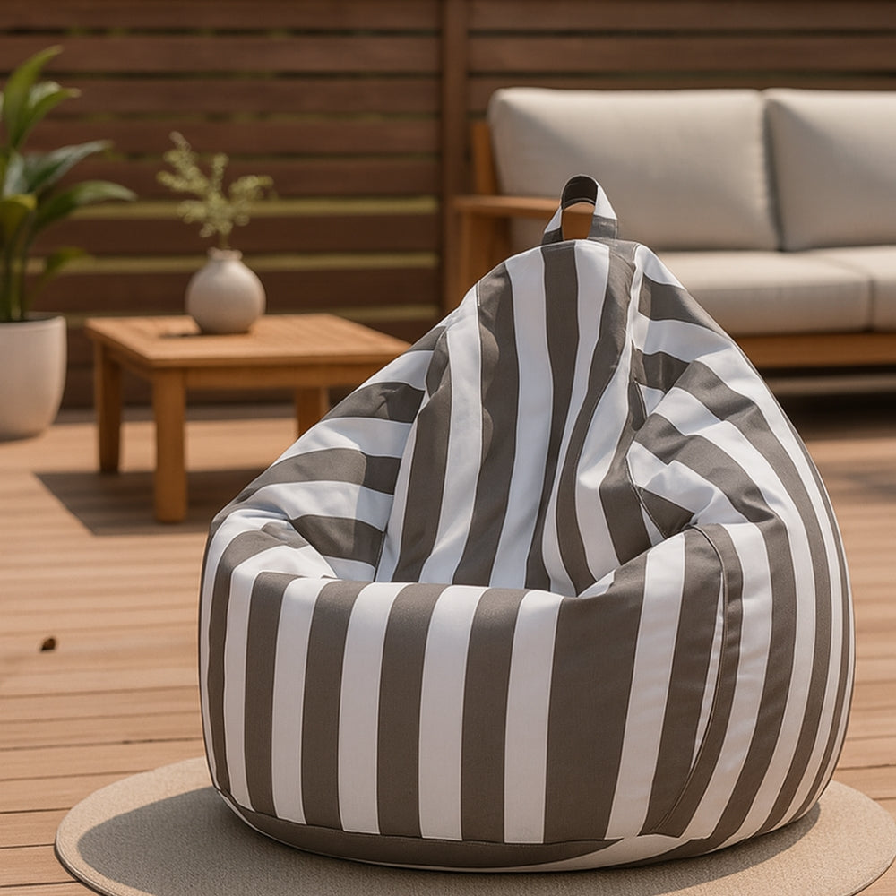 Light grey and white striped waterproof teardrop bean bag cover on a stylish outdoor timber deck with patio furniture.