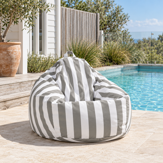 Light grey and white striped Hamptons teardrop outdoor beanbag beside a coastal home swimming pool.
