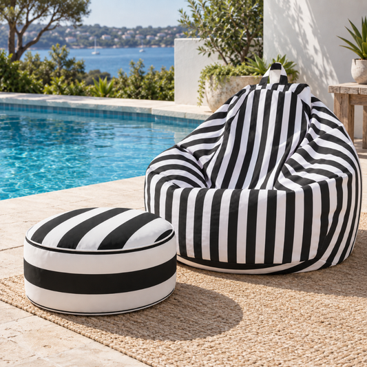 Black and white stripe outdoor inflatable ottoman styled beside a pool in an outdoor entertaining area.