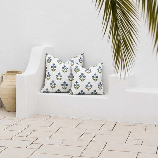 Two water-resistant Fleur blue floral outdoor cushion covers styled on a white santorini seat