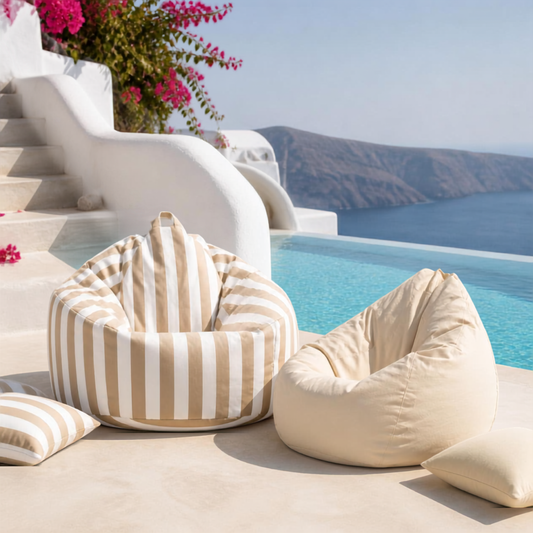 Light sand Mykonos weatherproof teardrop beanbag cover beside an infinity pool with Hamptons Light Sand striped beanbag seating and outdoor cushions.