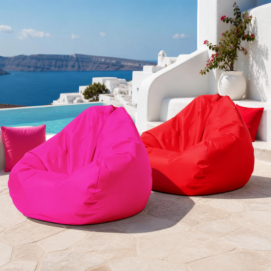 pink and red Mykonos weatherproof teardrop beanbag covers on a sunny poolside terrace overlooking the sea with Santorini red and pink cushion covers