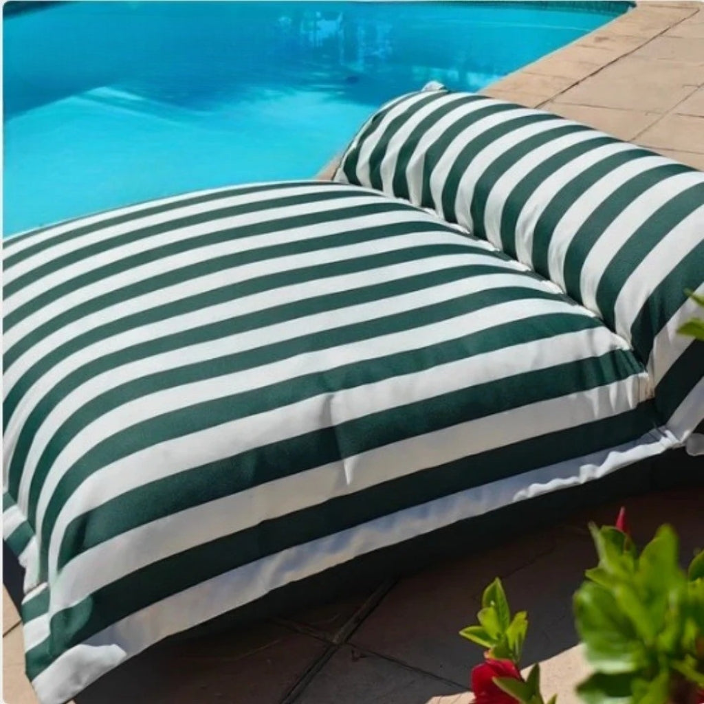 Close-up product image of the Big Bertha double floating beanbag lounger cover in dark green and white stripe, displayed beside an outdoor pool.