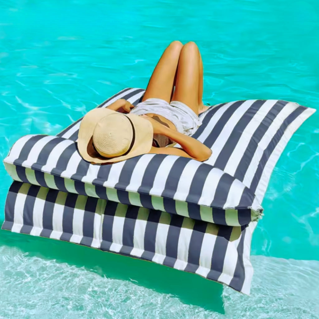 Product photo of the Big Bertha floating beanbag lounger cover in dark grey and white stripe, shown floating on clear pool water with detachable pillow.