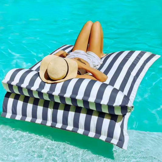 Product photo of the Big Bertha floating beanbag lounger cover in dark grey and white stripe, shown floating on clear pool water with detachable pillow.