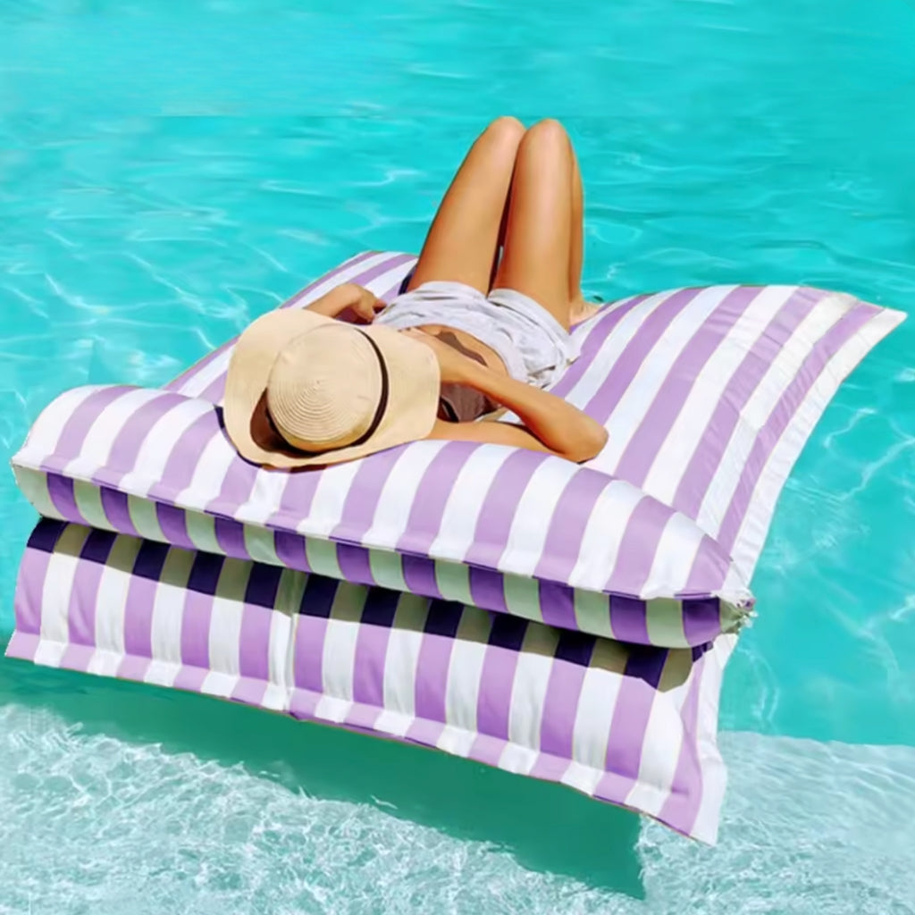 Product photo of the Big Bertha double floating beanbag lounger cover in purple and white stripe, shown floating on clear pool water with detachable pillow.