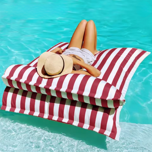 Product photo of the Big Bertha double floating beanbag lounger cover in red and white stripe, floating on bright blue pool water with the detachable pillow attached.