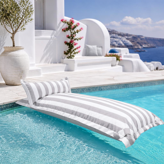 White and light grey striped Big Bertha Premium Single floating beanbag lounger cover in a swimming pool, 70 x 180 cm.