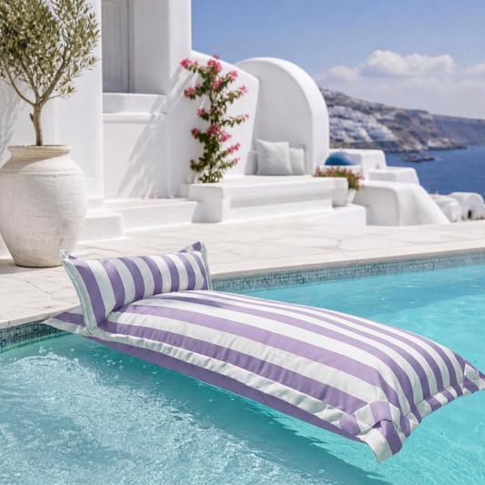 White and purple striped Big Bertha Premium Single floating beanbag lounger cover in a swimming pool, 70 x 180 cm.