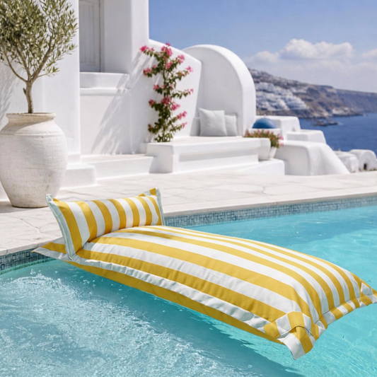 White and yellow striped Big Bertha Premium Single floating beanbag lounger cover in a swimming pool, 70 x 180 cm.