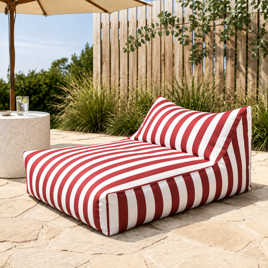 Red and white striped Big Chill weatherproof bean bag lounger in a sunny Australian coastal entertaining area with native greenery.
