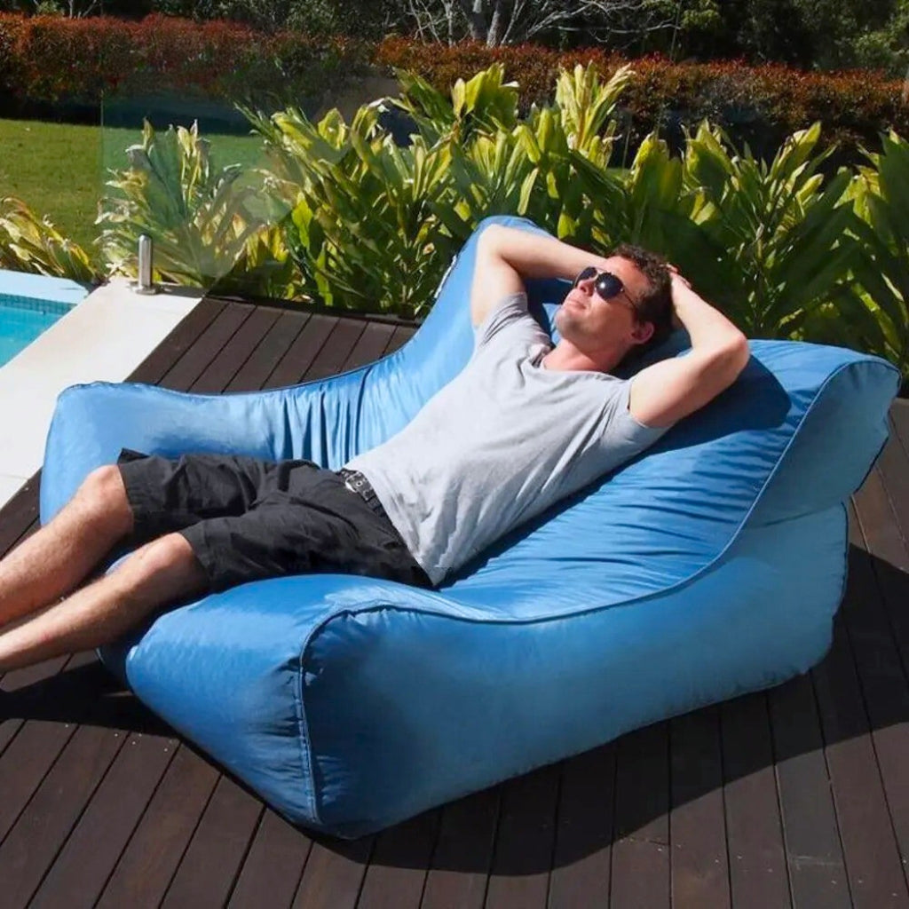 Bondi Premium Pool floating pool beanbag cover – Lake Blue, person floating on the lounger in a clear blue pool