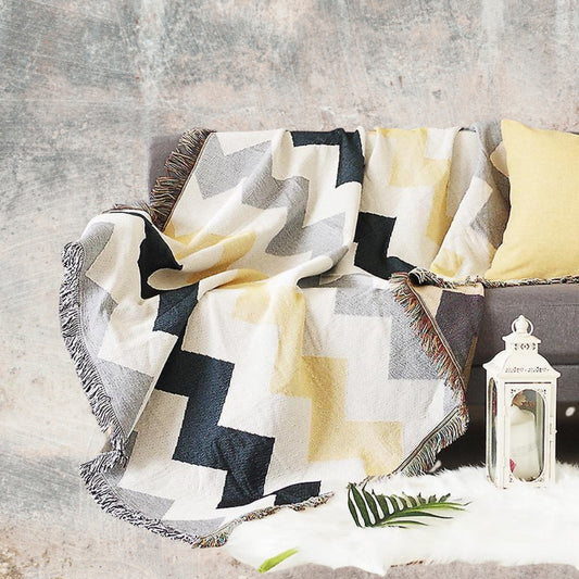 Coastal Picnic Rug in the Coastal Geo pattern, jacquard-woven cotton with tassel edging, shown draped for outdoor or indoor use.