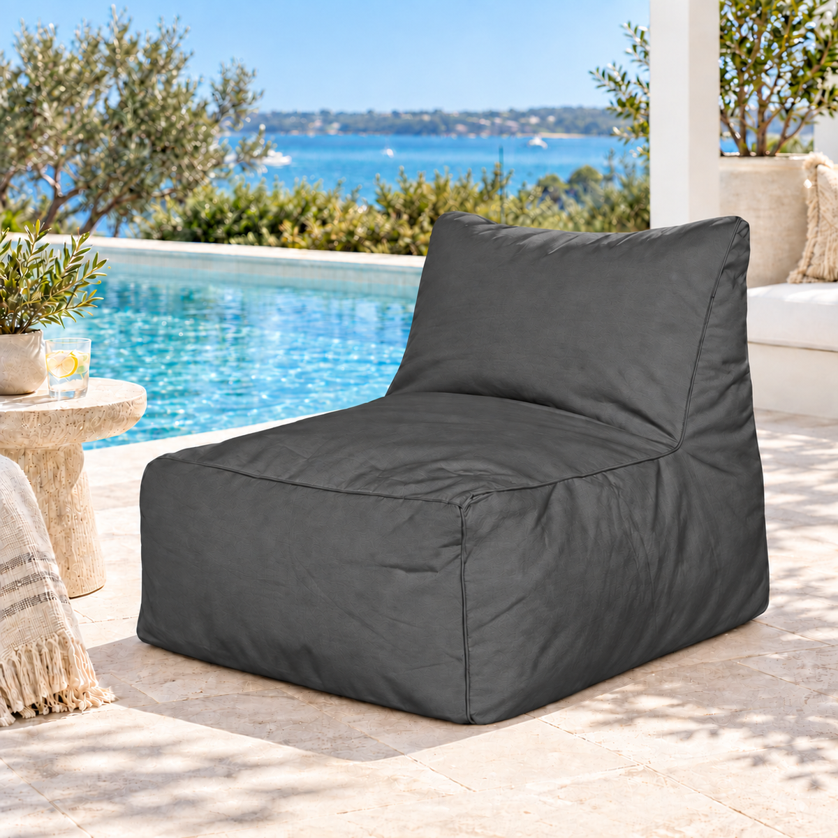 Dark charcoal Hamptons outdoor bean bag lounge chair styled in a coastal poolside setting