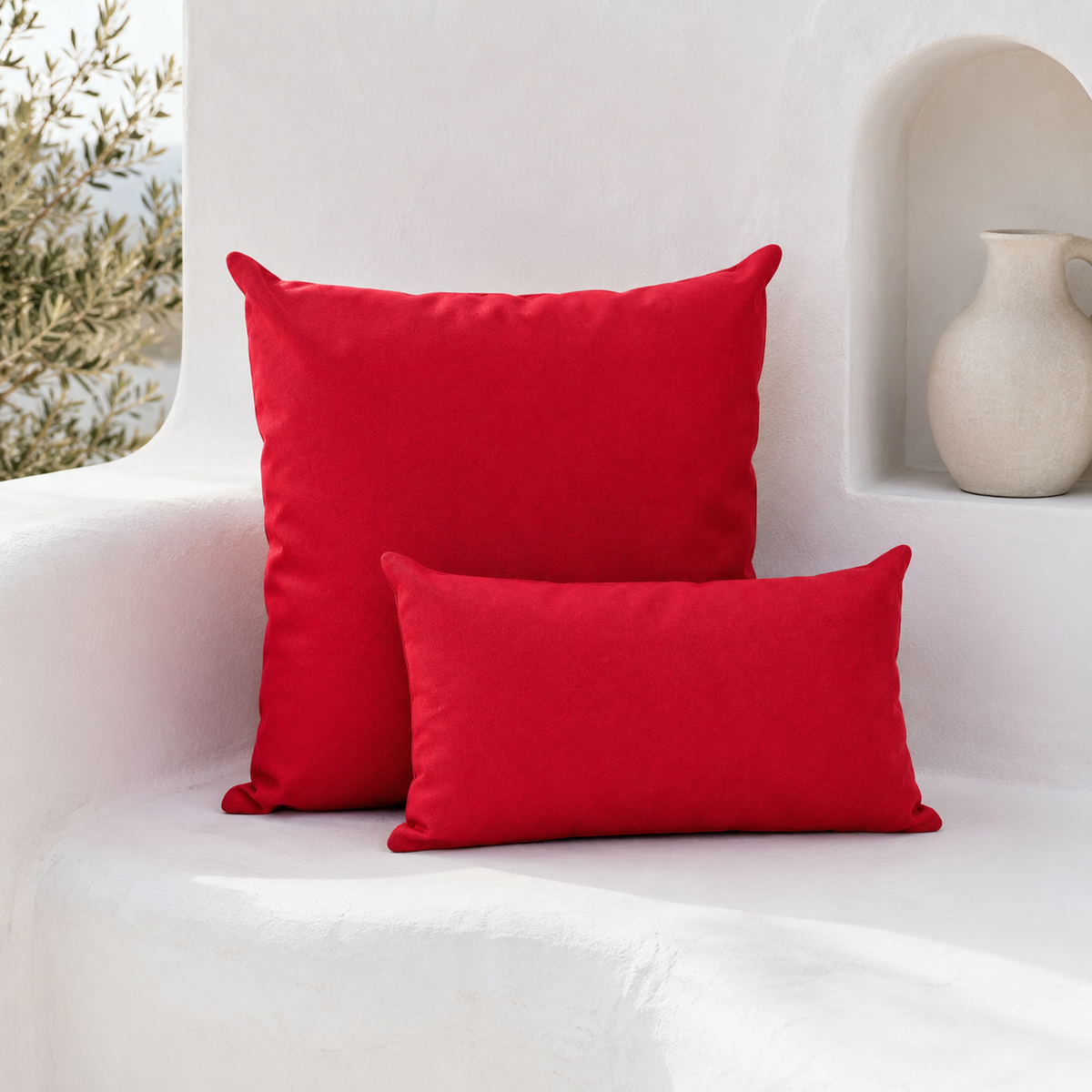 Santorini red weatherproof outdoor square and lumbar cushions styled on a white Mediterranean bench