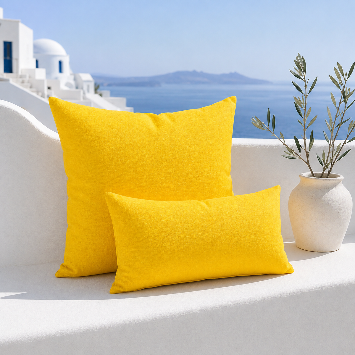 Santorini yellow weatherproof outdoor square and lumbar cushions styled in a bright white Mediterranean outdoor setting