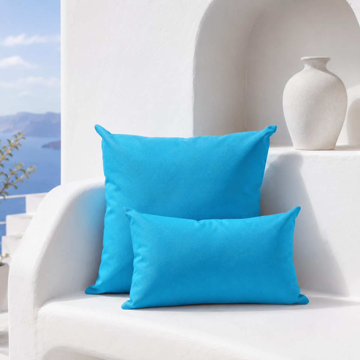 Santorini blue weatherproof outdoor square and lumbar cushions styled in a bright white Mediterranean setting