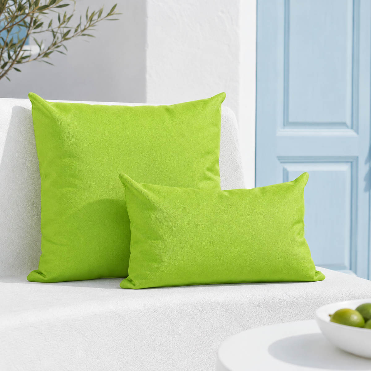 Santorini green weatherproof outdoor square and lumbar cushions styled on a white Santorini terrace with pale blue door