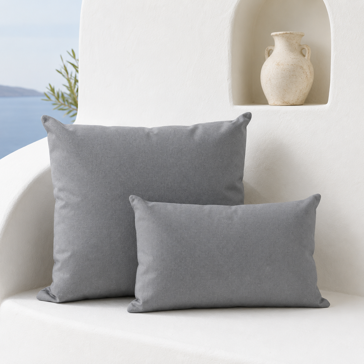 Santorini grey weatherproof outdoor square and lumbar cushions styled in a bright white Mediterranean seating nook