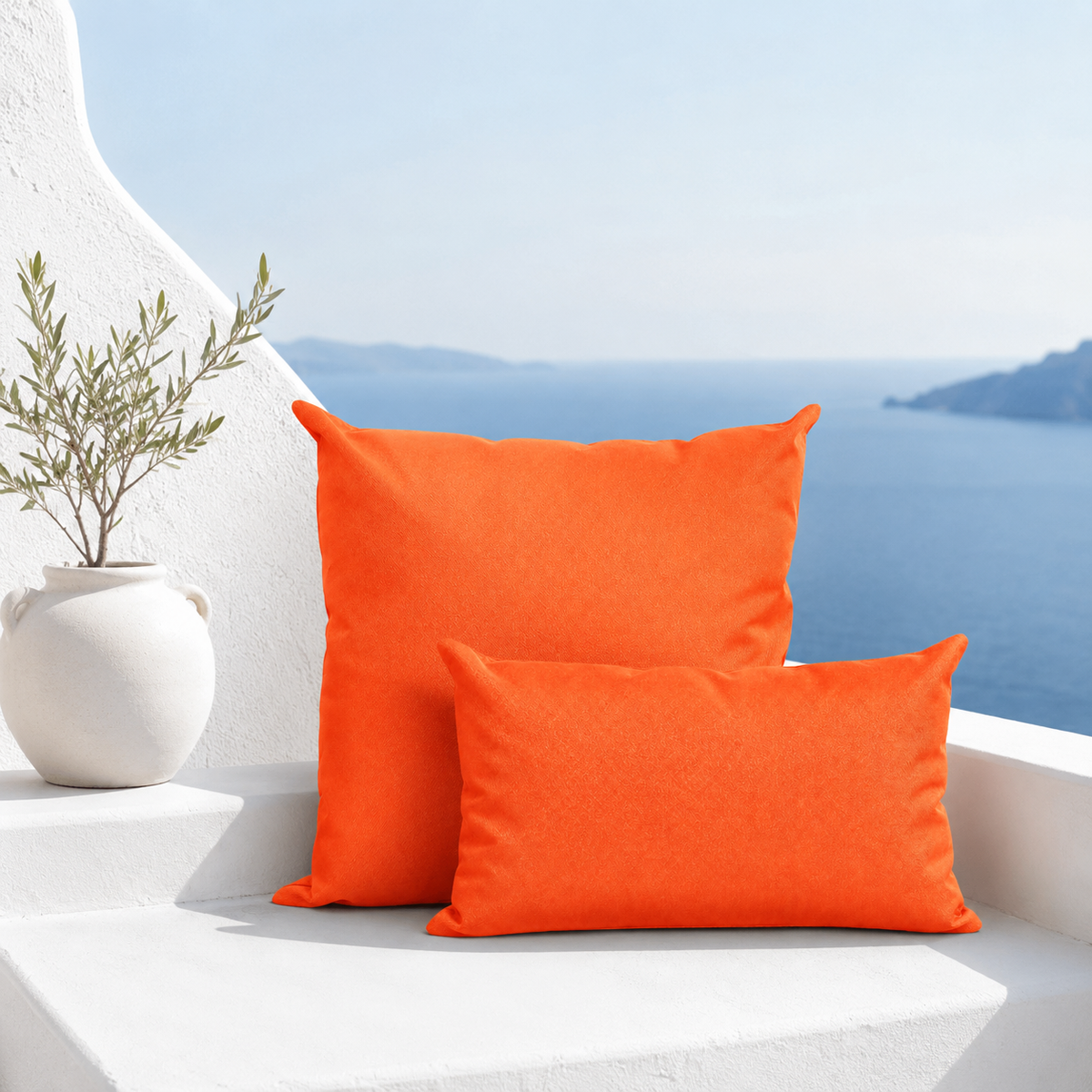 Santorini orange weatherproof outdoor square and lumbar cushions styled on a white Santorini bench with sea view